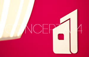 Detalle de logotipo corpóreo sobre pared de color corporativo. Reformas Madrid